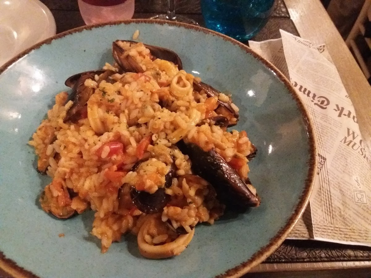 Rissotto ai fruti di mare. The newspaperlike wrapping contains the cutlery