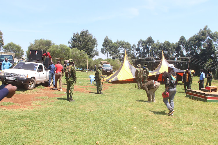 Event planners pull down tents and prepare to leave the Kebirigo Primary grounds as police keep watch on October 8.