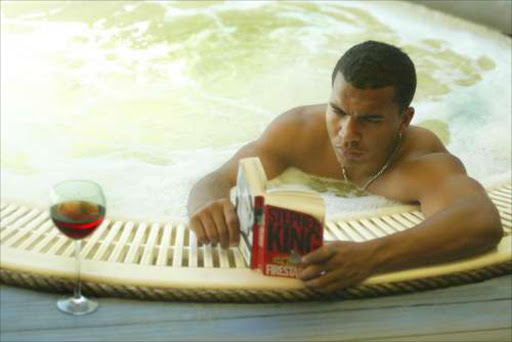 MODERN MAN; Alex Holi took part in the show last year. 23/07/7. Sowetan. M-Net Reality TV show Big Brother Africa housemate Alex Holi from Kenya relaxes in the jacuzzi while reading a Styephen King novel and drinking a glass of red wine. Pic: Elizabeth Sejake. © ST.