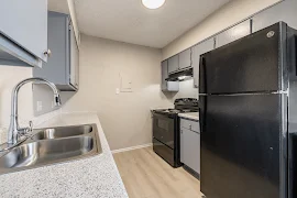 Kitchen featuring stainless steel appliances, stone-inspired countertops, and ample cabinet space setting.