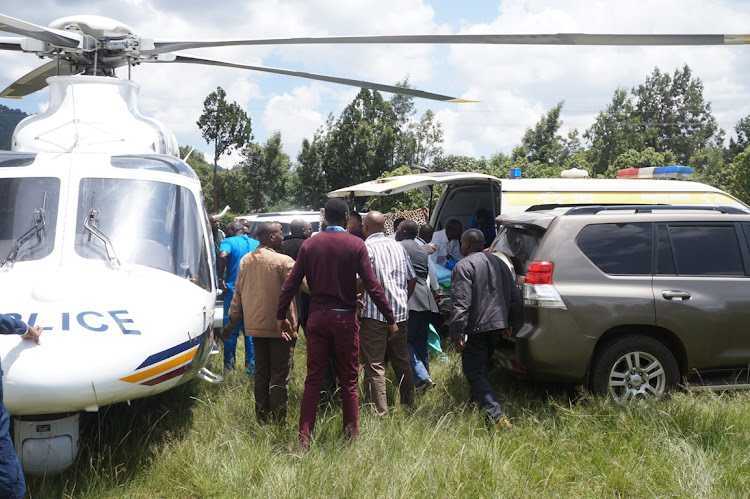 Kijabe hospital staff and the police remove Jubilee Party secretary general Raphael Tuju from an ambulance placing him in a police helicopter yesterday as they prepare to airlift him to Karen Hospital.