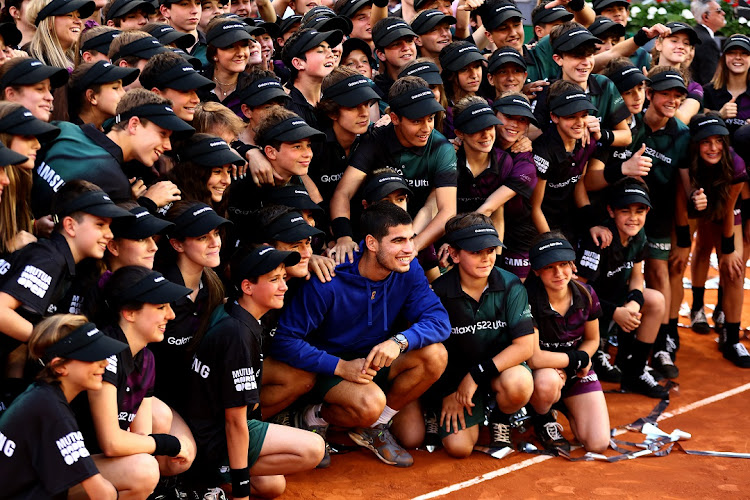 Carlos Alcaraz of Spain poses for photographs with the ball kids after his straight sets victory in the men's singles final against Alexander Zverev of Germany at the Madrid Open at on May 8 2022.