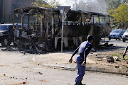 June 21, 2016. A delivery truck and a bus were set alight by angry residents of Atteridgeville, west of Pretoria. Residents brought the township to a standstill following the announcement that Parliament House Chairperson Thoko Didiza will be the mayor of Tshwane should the ANC retain the municipality later this year. Police later arrived to clean the streets while looting continued. PHOTO:PETER MOGAKI