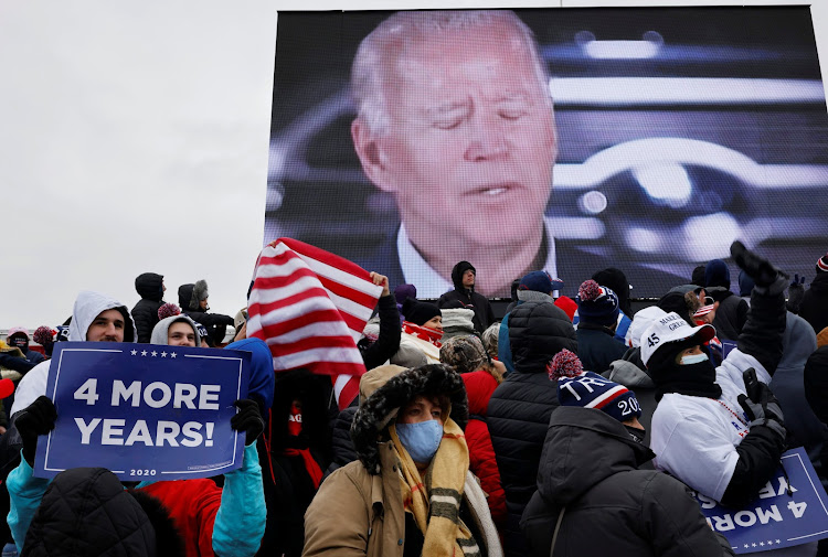 Democratic US presidential nominee and former Vice President Joe Biden on a screen as supporters attend a campaign rally by President Donald Trump at Michigan Sports Stars Park in Washington, Michigan, November 1.