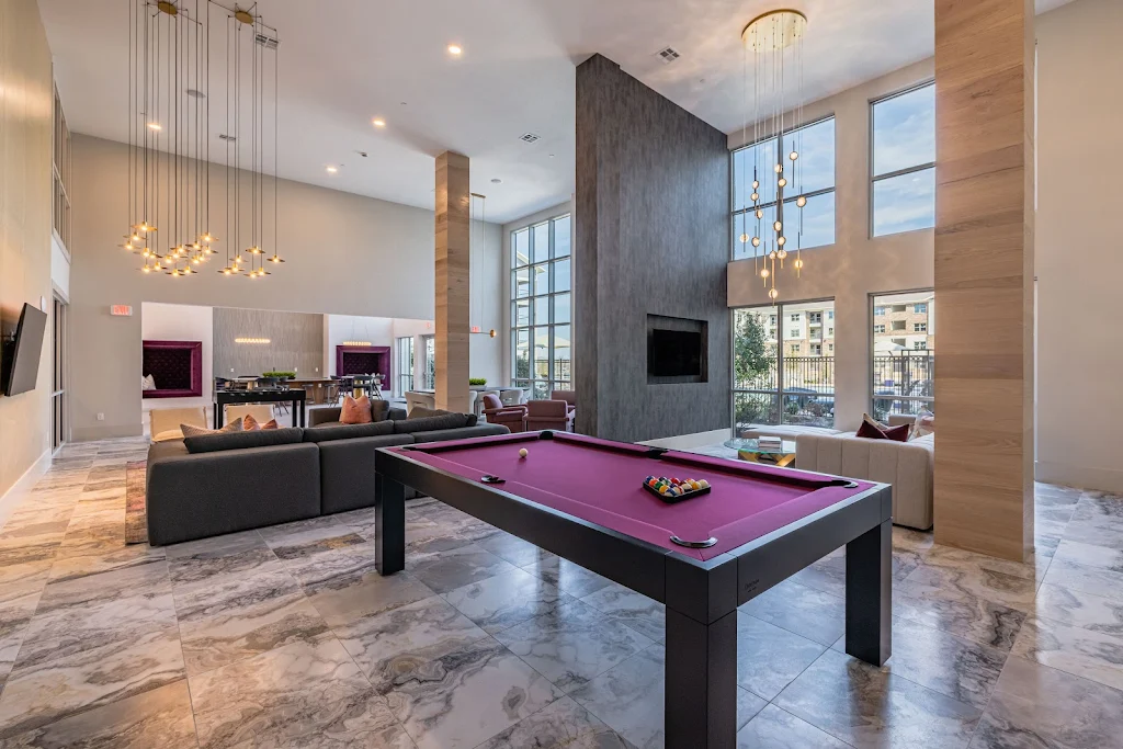 Modern apartment complex lobby with pool table, seating area, and elegant lighting.