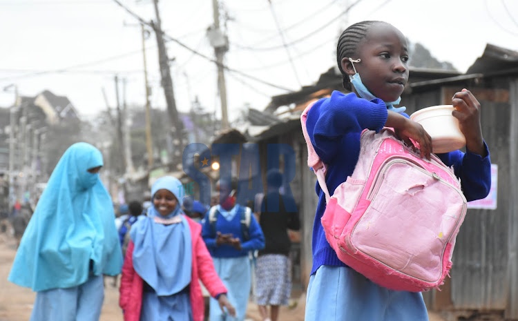 A pupil walks to school during school reopening for their second term of the year 2020 school calendar. She is seen walking without wearing her facemask properly. She stands at a risk of conducting the covid-19 virus,