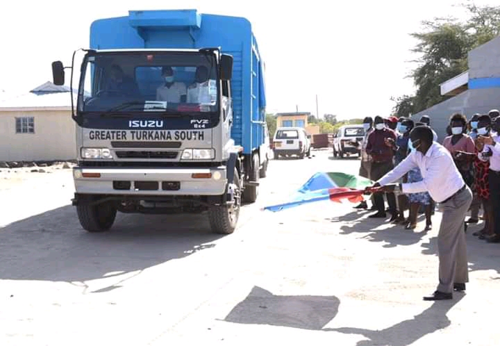 Agriculture and Pastoral Economy executive Philip Aemun flags off vehicles casupplementary livstock feed.