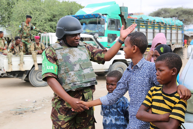 A KDF officer interacts with Somalia locals in Dhobley.