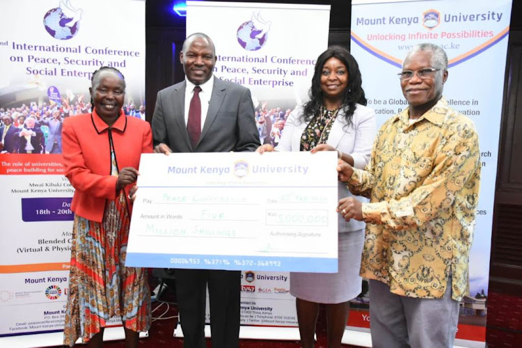 Peace ambassador Tecla Lorupe receives a dummy cheque of Sh5 million from MKU pro-chancellor Dr Vincent Gaitho, MKU co-founder Jane Nyutu and NCIC chairman Samuel Kobia during a breakfast meeting held at a Nairobi hotel.