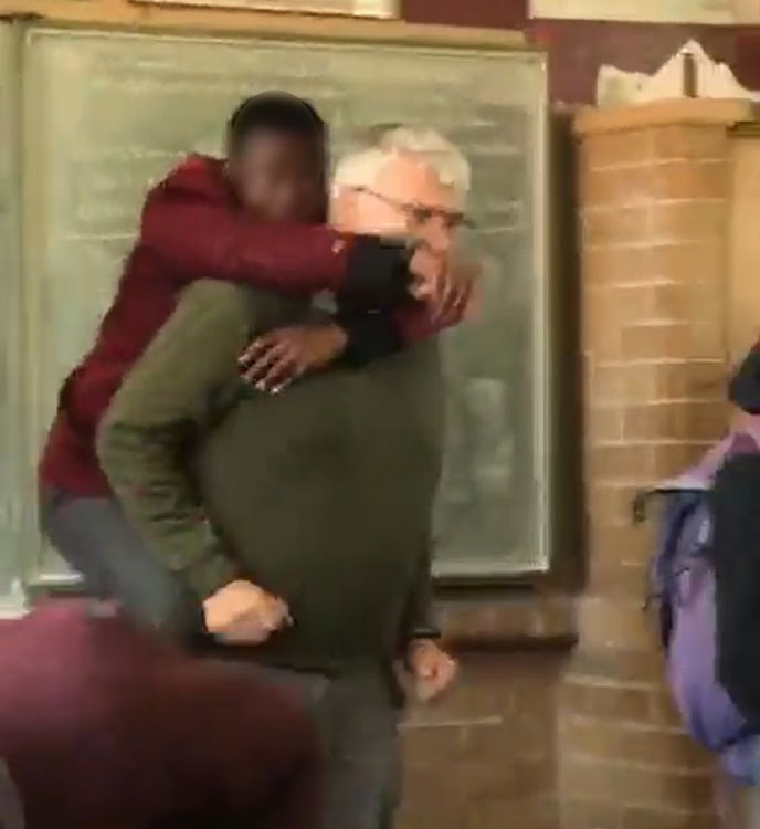 Pupils cheered as some threw punches at each other, while teacher David Botha desperately tried to free himself