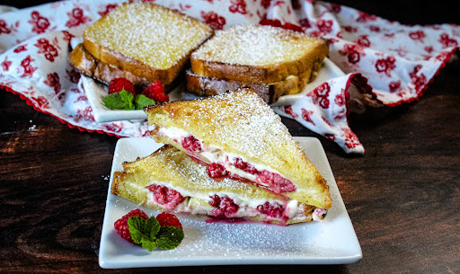 Raspberry and Cream Cheese Stuffed French Toast sliced in half.