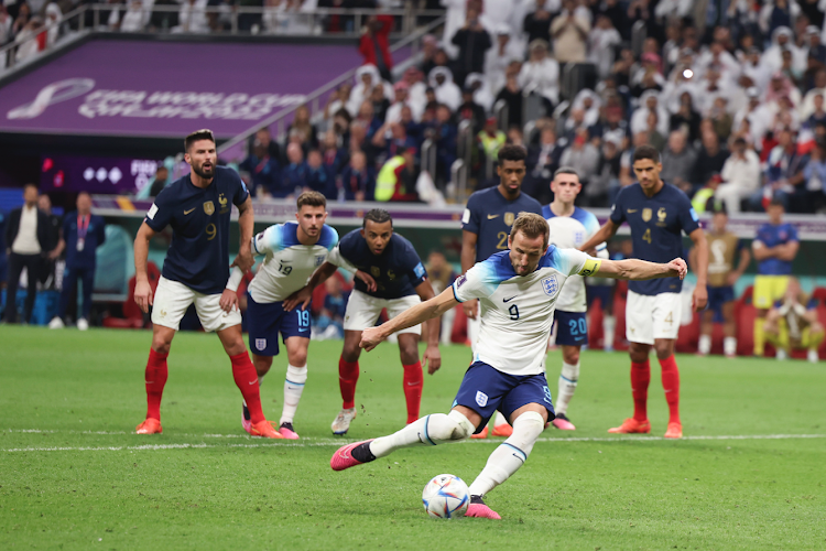 Harry Kane (front) of England shoots the second penalty shot during the Quarterfinalagainst France at the 2022 FIFA World Cup at Al Bayt Stadium in Al Khor, Qatar, Dec. 10, 2022.