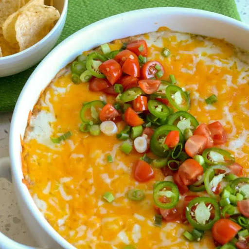 This super creamy, flavorful refried bean dip is a party favorite.  It comes together in less than fifteen minutes of prep time and reheats perfectly at a reduced power level in the microwave.