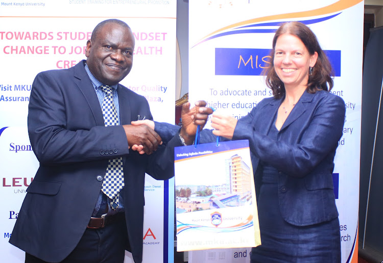 Mount Kenya University VC Stanley Waudo presents a gift to head of Culture and Education at the German Embassy Madam Ursula Koos on MKU Thika campus on April 30