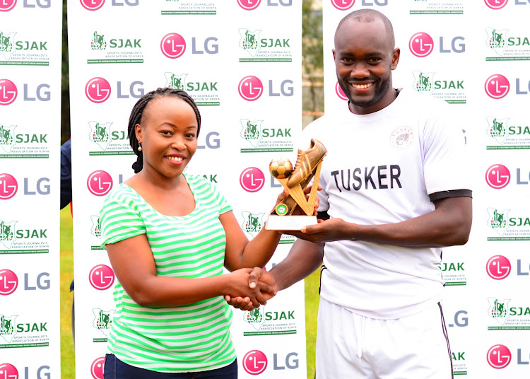 Timothy Otieno receives the SJAK player of the month award from LG's Maureen Kemunto yesterday at the Ruaraka grounds