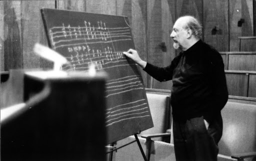 Matz writes music on chalkboard, ca. 1970s