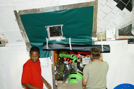 Workers in the Orbiter Processing Facility cover up areas of Atlantis preparing for the impact of Hurricane Frances.