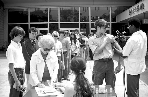 This historic image depicts a line of people each awaiting a New Jersey Influenza vaccination