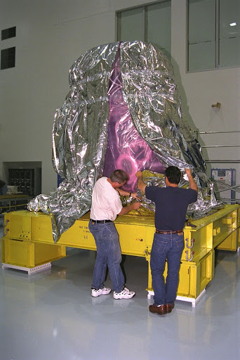 International Space Station ISS contractors unwrap Pressurized Mating for the ISS in KSC's Space Station Processing Facility.