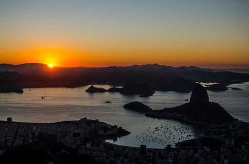 Vista do Pão de Açúcar, Praia de Botafogo e Urca com montanhas ao fundo com a primeira luz do dia