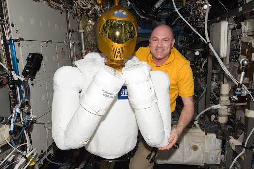 European Space Agency astronaut Andre Kuipers poses for a photo with Robonaut 2 humanoid robot in the Destiny laboratory of the International Space Station.