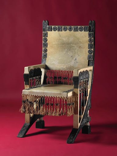 Armstoel van notenhout, ingelegd met quasi oosterse karakters van tin