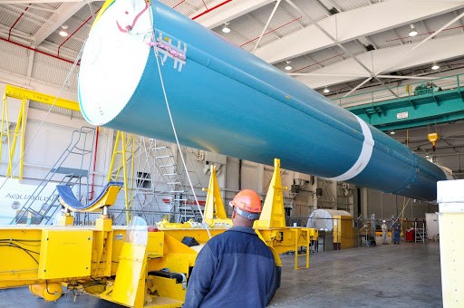 Crane is used to offload the first stage of a United Launch Alliance Delta II rocket following its arrival at NASA hangar 836 on Vandenberg Air Force Base.
