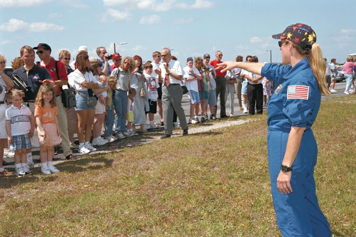 Mission Specialist Kathryn Kay Hire waves to friends and family members are scheduled to launch aboard Columbia.