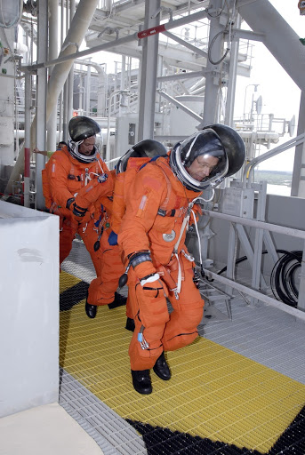 Danny Olivas Nicole Stott and Christer Fuglesang hurry to the slidewire basket area on NASA Kennedy Space Center's fixed service structure.