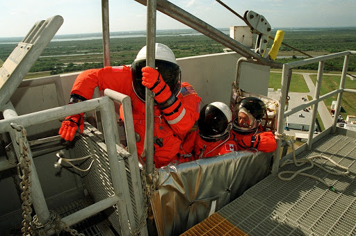 Joe Tanner reaches for the lever to release the slidewire basket that holds Mission Specialists Marc Garneau and Carlos Noriega.