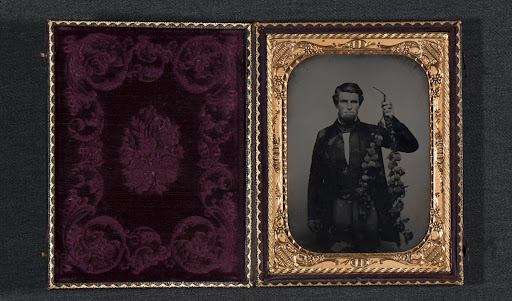 Northern California pioneer Levi Tower holds a peach tree branch from his orchard.