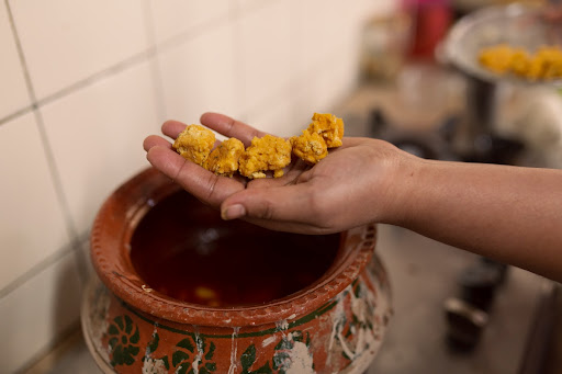 Adding lentil nuggets to prepare Vadiyun ka Salan (Lentil nugget and vegetable gravy), in Sukkur