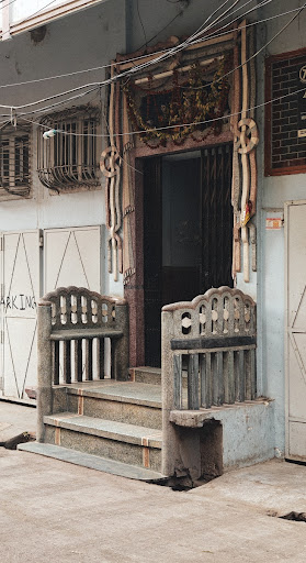 Chabutra outside a house with cemented railings and an ornate door frame.