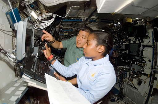 Wilson and Tani in the U.S. Lab during Expedition 16/STS-120 joint operations