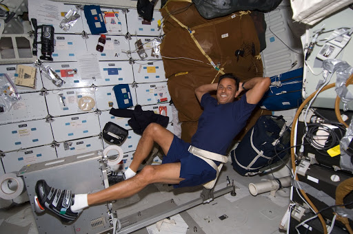 Astronaut strapped into cycling equipment while in space.