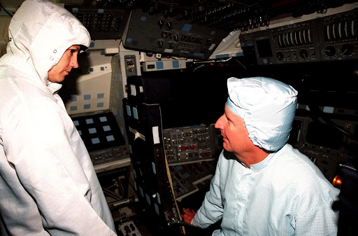 STS-93 Mission Commander Eileen M. Collins listens to Mission Specialist Steven A. Hawley during the Crew Equipment Interface Test.