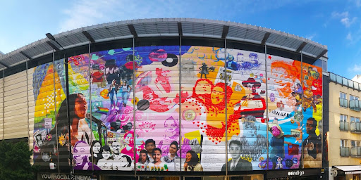 The Culture for a Changing City Community Mural was our second collaborative public artwork with Paint the Change, to welcome people back and celebrate the local area as we came out of lockdown. Working with long-term partner Halima Khanom and local community groups, this mural reflected on the people that make up Tower Hamlets, and captured their personal stories with portraits and artwork of cherished items.