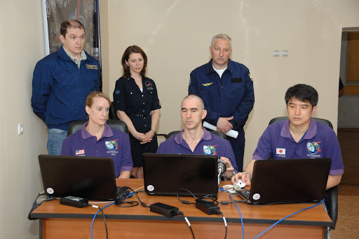 At the Cosmonaut Hotel in Baikonur, Kazakhstan, Expedition 48-49 crewmembers Kate Rubins of NASA (left), Anatoly Ivanishin of Roscosmos (center) and Takuya Onishi of the Japan Aerospace Exploration Agency (right) conduct rendezvous rehearsals on a laptop computer simulator June 30 as instructors look on. Rubins, Ivanishin and Onishi will launch July 7, Baikonur time, on the Soyuz MS-01 spacecraft for a planned four-month mission on the International Space Station...NASA/Alexander Vysotsky.