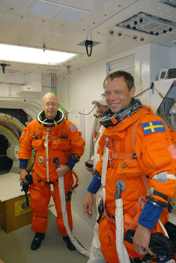 Patrick Forrester left and Christer Fuglesang wait for cool air to be pumped through their suits before entering Discovery.