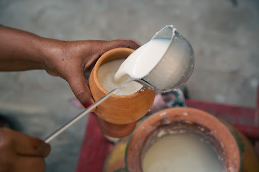 Pouring lassi ( buttermilk ) into pot, at PODA, in Islamabad