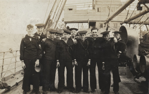 Sailors on deck of USS Malang in dress blues.