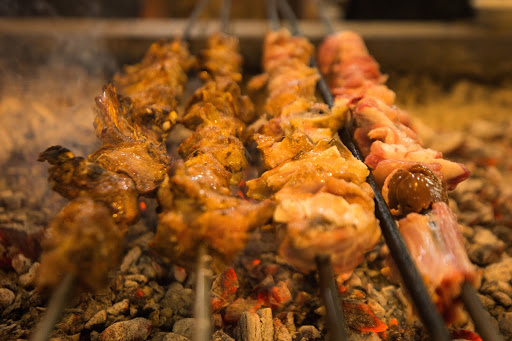 Skewered meat cooking over a coal fire