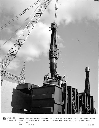 Inserting high-voltage bushing, rated 2050 KV BIL, into project EHV power transformer rated 650 KV (750 KV MAX.), 40,000 KVA, 1925 BIL. Pittsfield, Mass., Oct., 1960