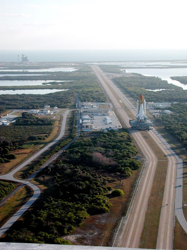 Photographed from the top of the Vehicle Assembly Building, Space Shuttle Atlantis creeps along the crawlerway.