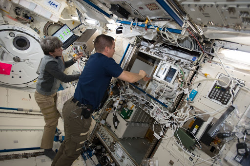 Peggy Whitson and Jack Fischer work on station systems inside Japan's Kibo laboratory module.