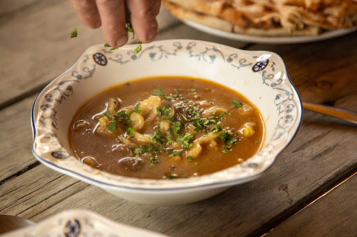 Adding coriander to the kali soup