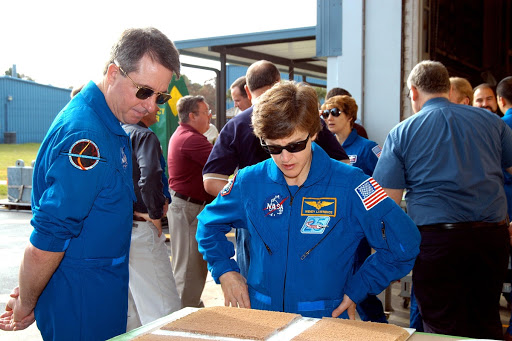STS-114 Mission Specialists Stephen Robinson and Wendy Lawrence look at a test panel of insulation material cut in a liquid nitrogen process.