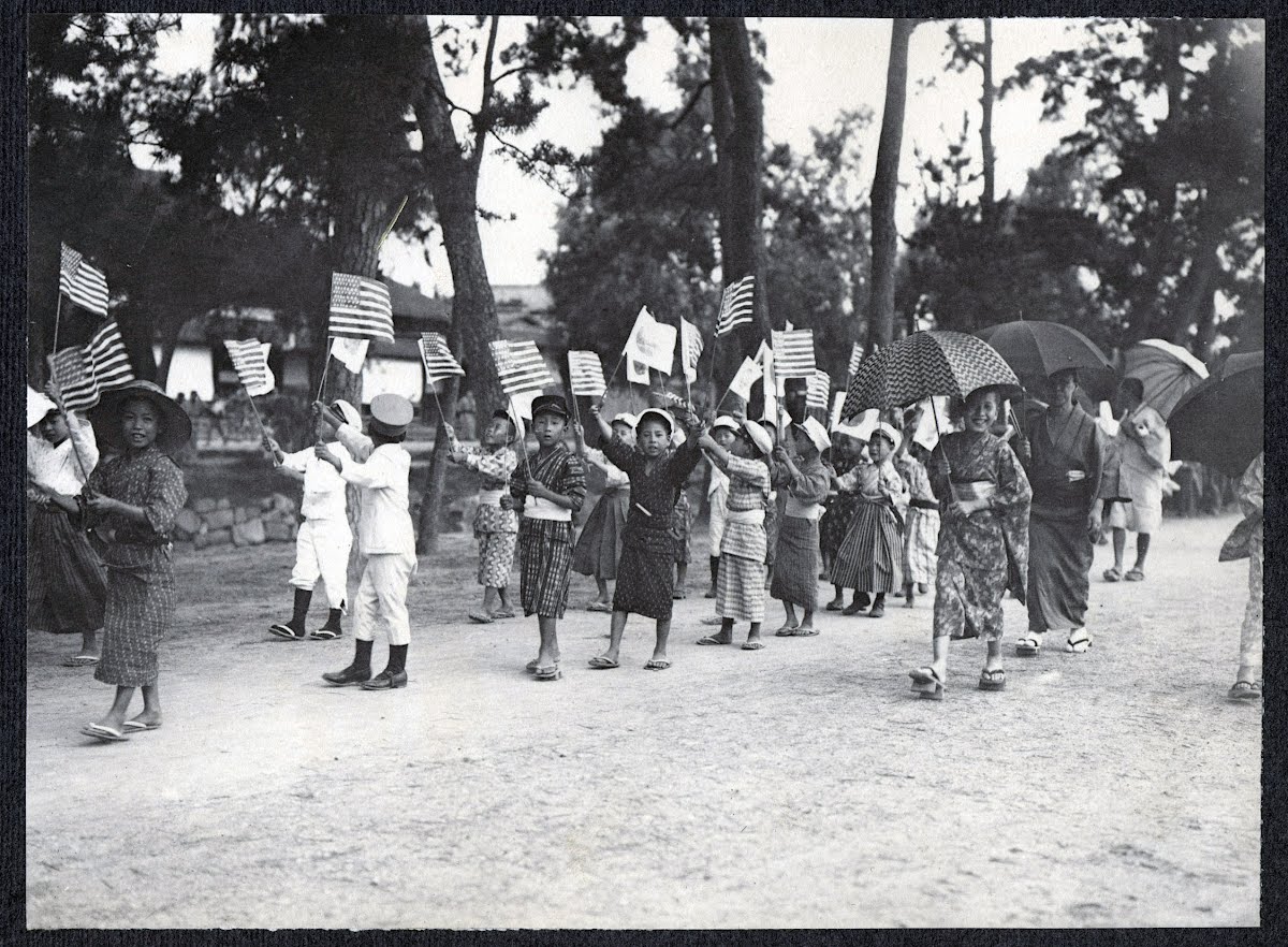 Children parading with American and Japanese flags