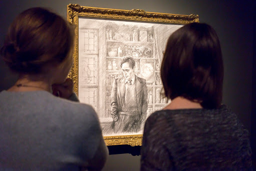 Visitors looking at Jim Kay's portrait of Professor Lupin