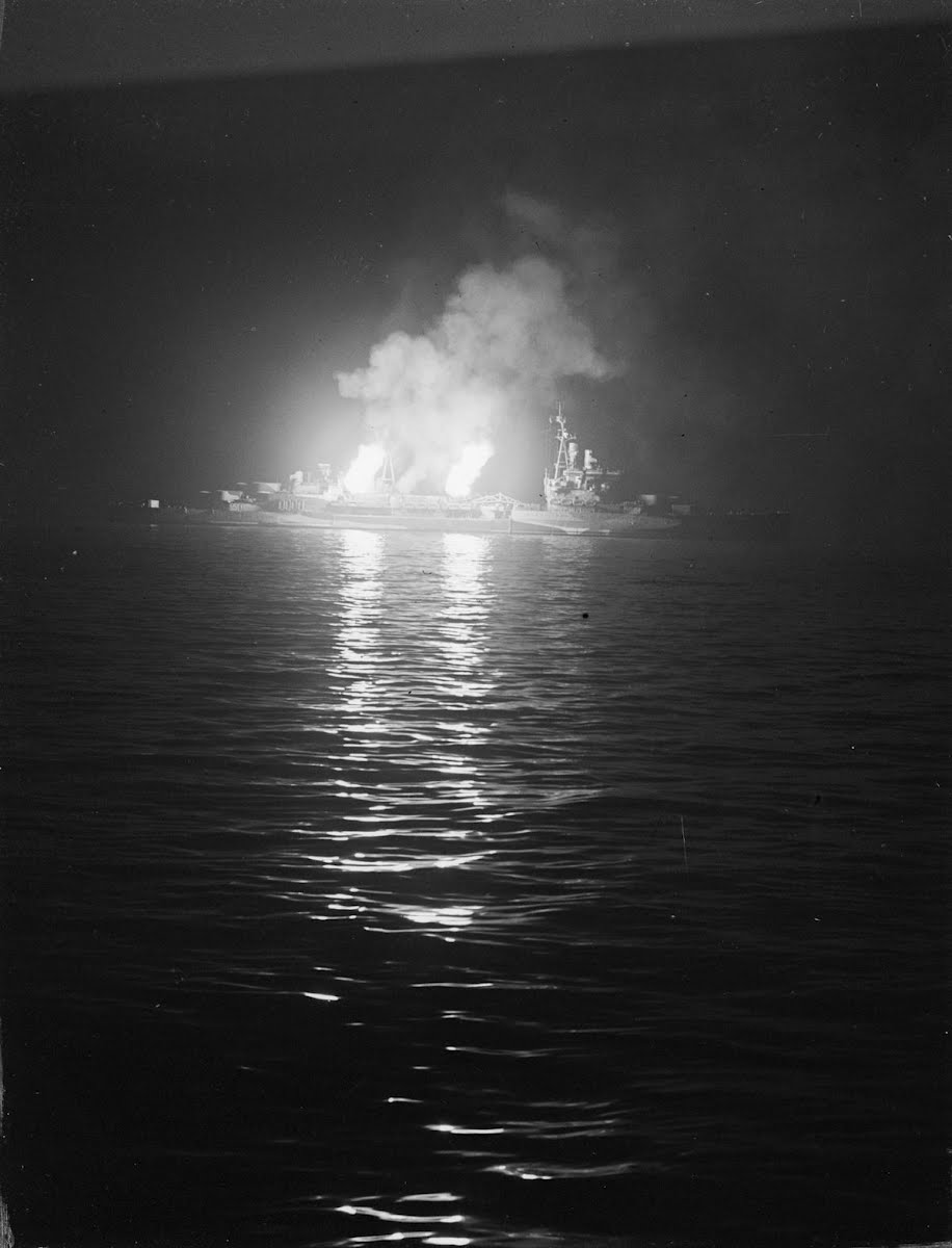 Starboard 4 inch guns of HMS Belfast open fire on German positions around Ver-sur-Mer on the night of 27 June 1945